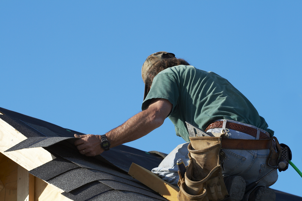 worker replacing roof