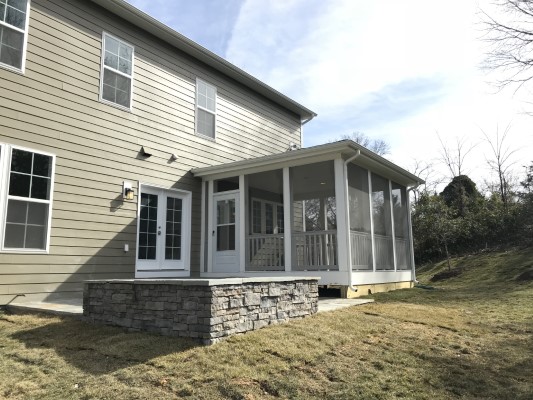 screen porch with patio and stone wall