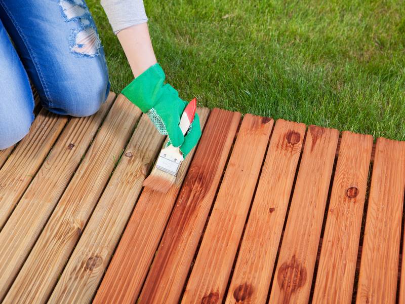 woman staining deck