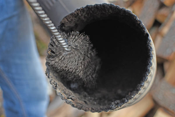 cleaning chimney pipe as part of preventative roof maintenance