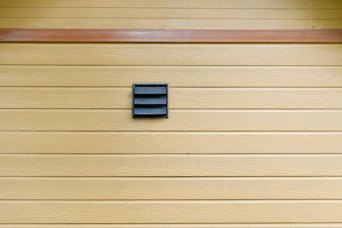 Black ventilation duct looks sharp on a tan vinyl-sided home