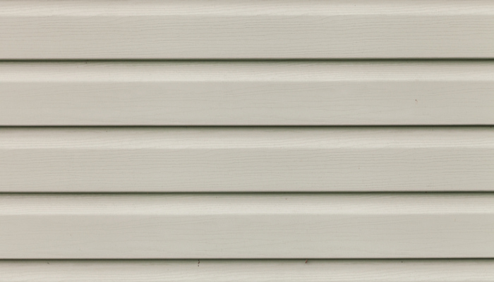Close up of Light gray or dirty white insulated vinyl wooden home siding panel with imitation wood texture