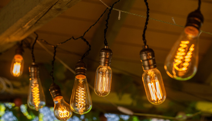 Screened porch string lights hanging on a line in backyard in spring