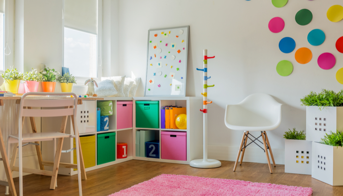 Colorful designed unisex kids room with stickers on the wwall and pink carpet on the floor