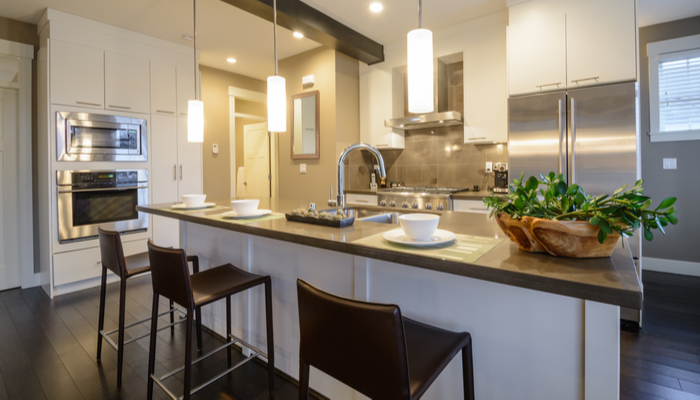 Modern, bright, clean, modern kitchen interior with bright lights nad stainless steel appliances in a luxury house