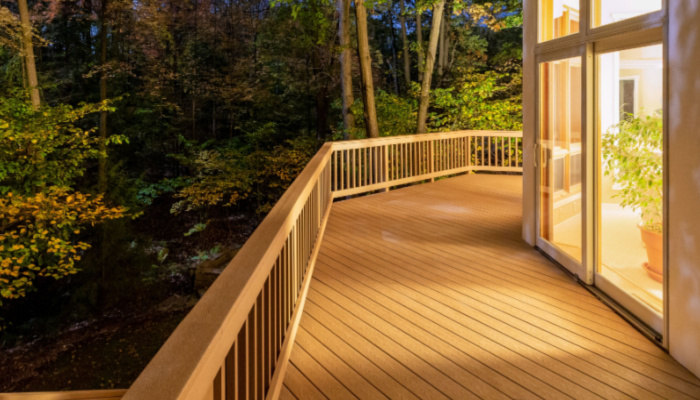 Large composite deck on a luxury home in the woods photographed at night