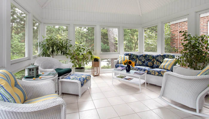 Screened Porch with white floor and plants and furnitures with cushions