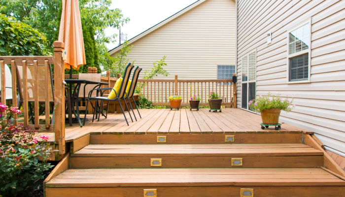 Deck with furnitures and lots of plants of family home at summer