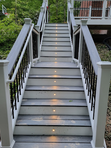 Large white and gray colored deck with stairs with beautiful lighting