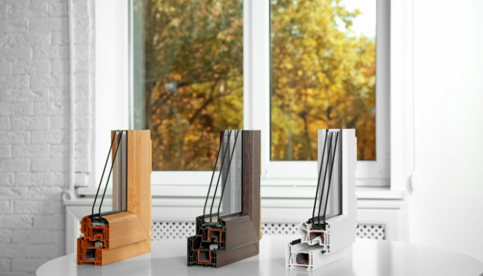 Samples of modern double and triple pane window profiles on table indoors