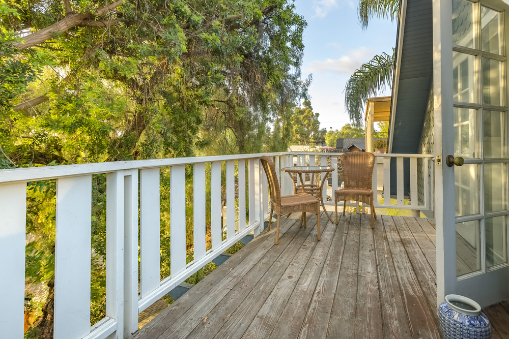 An upstairs balcony in a beautiful California home at sunset, featuring a patio area
